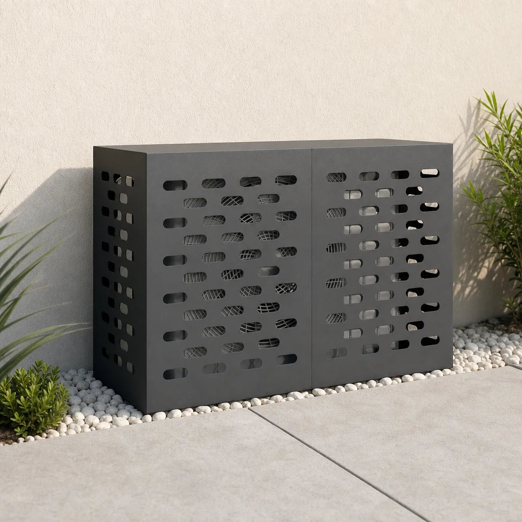 Cache clim extérieur noir installé contre un mur, entouré de plantes