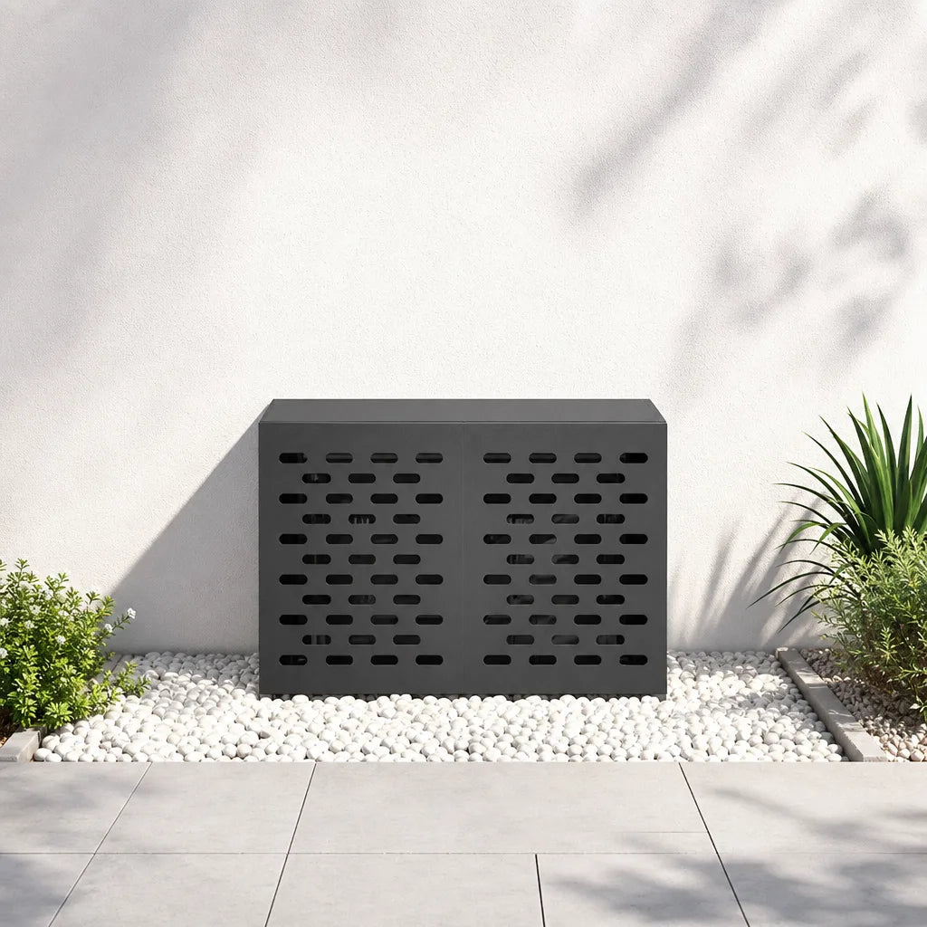 Cache clim extérieur noir posé sur une terrasse, ombre de végétation sur la façade

