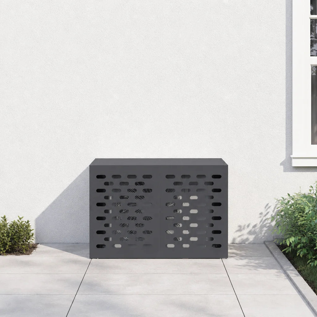 Cache clim extérieur anthracite posé contre une façade, entouré d'arbustes
